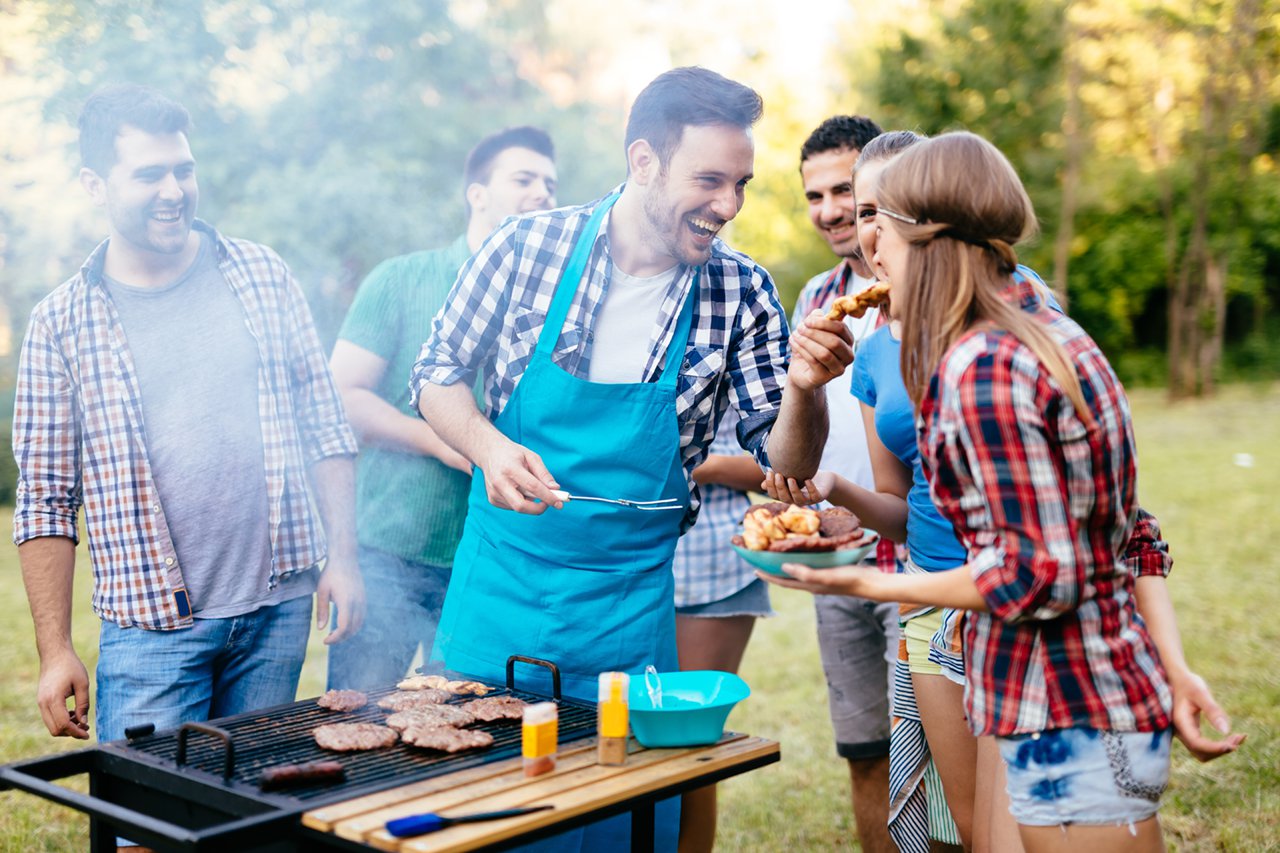 Friends having a barbecue party in nature while having a blast